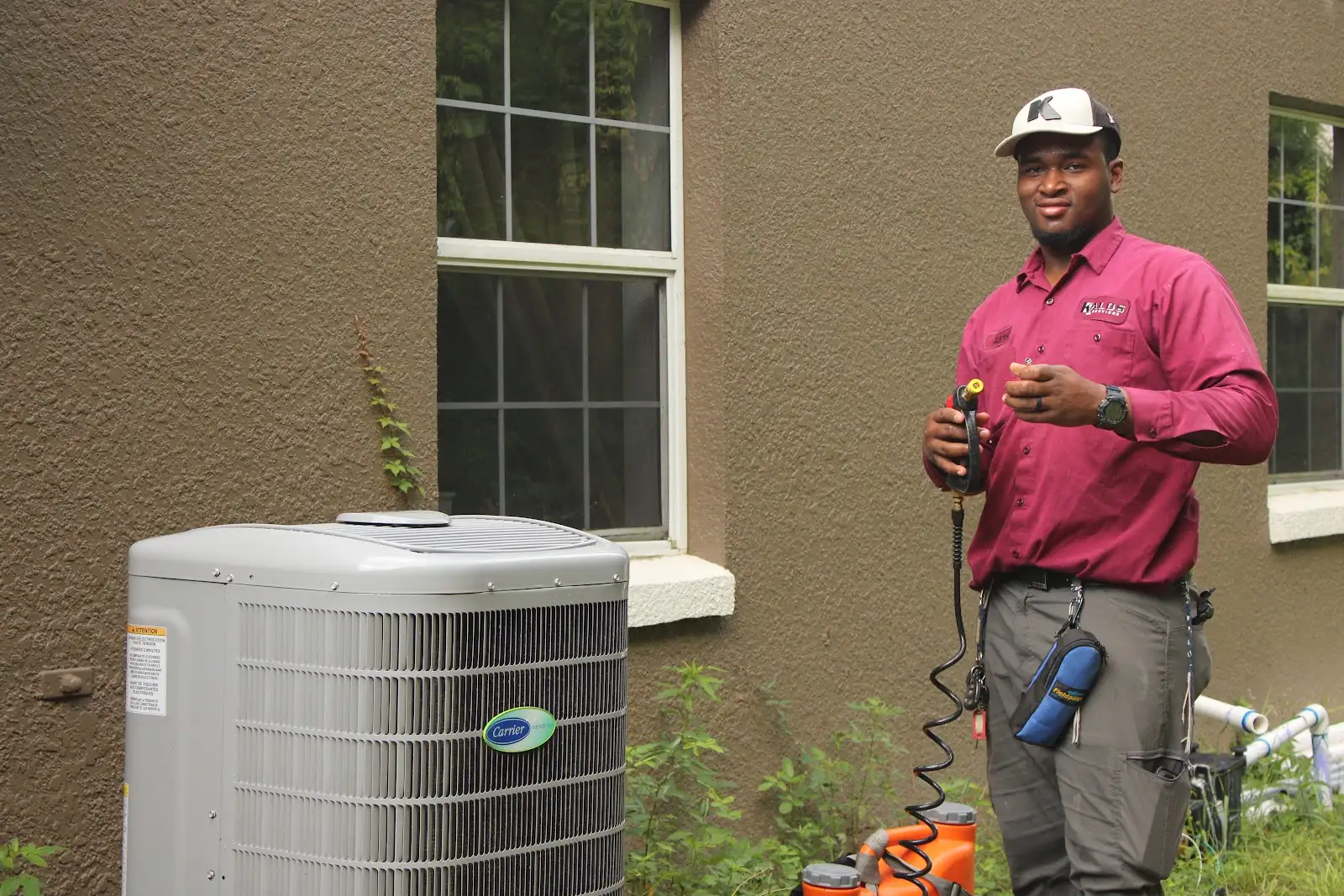Kalos HVAC technician inspecting outdoor air-conditioning equipment at a Central Florida home.