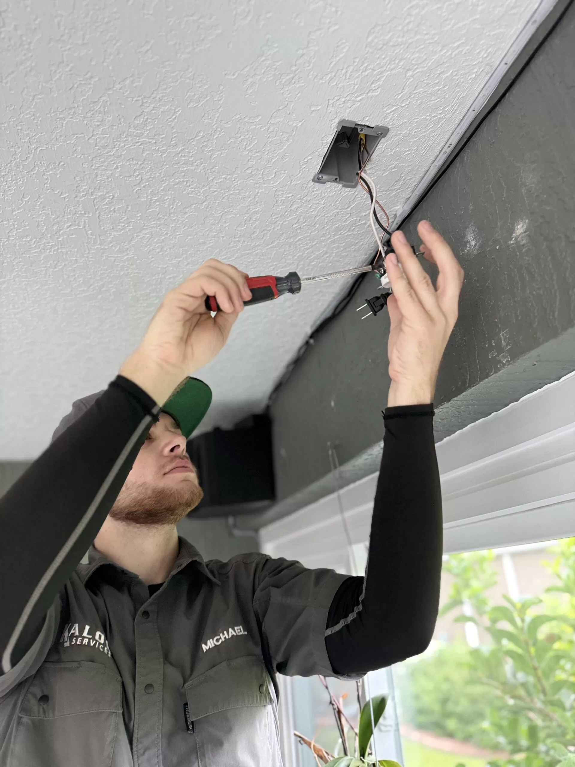 Kalos electrical technician replacing wiring at a ceiling outlet box
