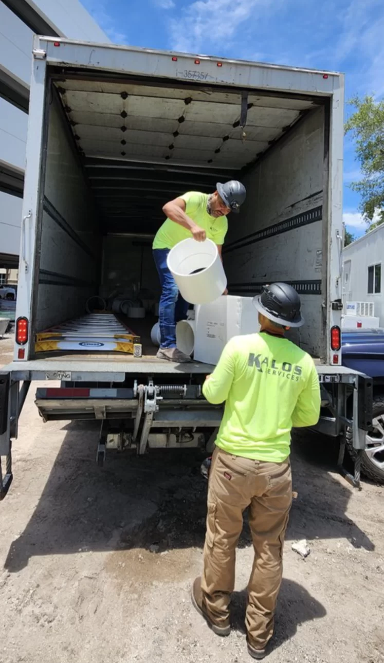 Two Kalos employees working together while unloading materials