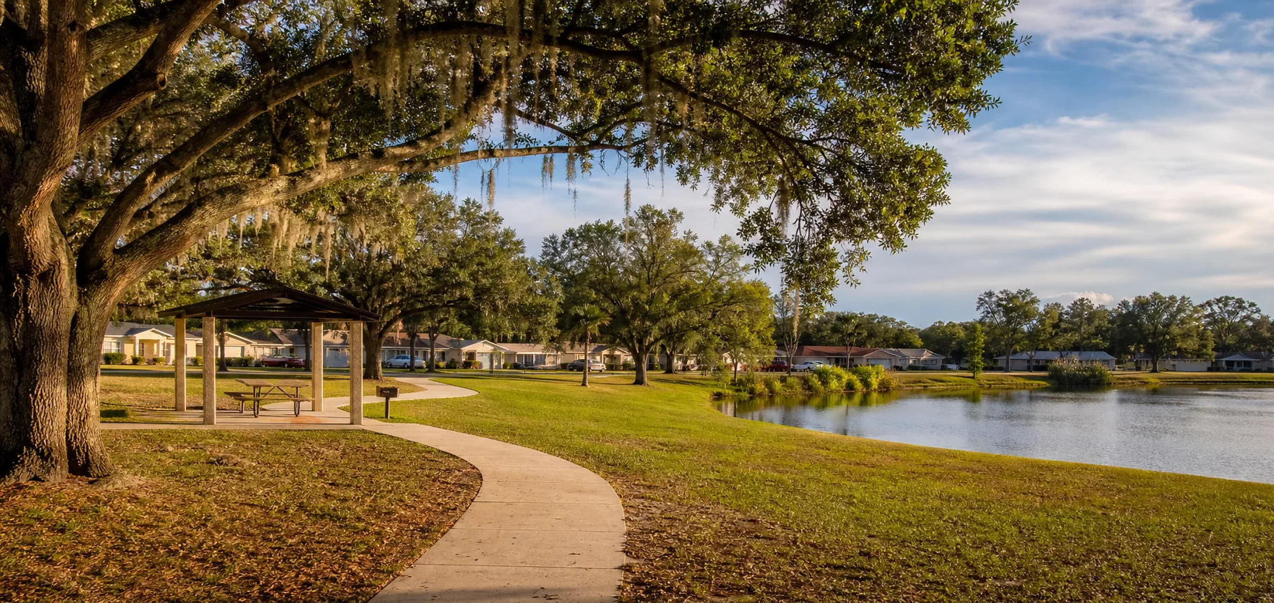Groveland,neighborhood, shaded path, park pavilion, and lake representing Pine Hills, Florida.